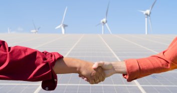 alternative energy - two engineers shaking hands making deal on solar panels plant, green energy and eco friendly industry concept