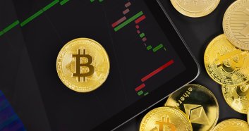 Overhead view of Bitcoin on digital tablet with graph by various crypto coins. BTC as hedge in recession