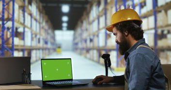 Customs compliance officer uses greenscreen pc in warehouse, looking at isolated chromakey display. Male depot employee working with package shipment and blank copyspace template.